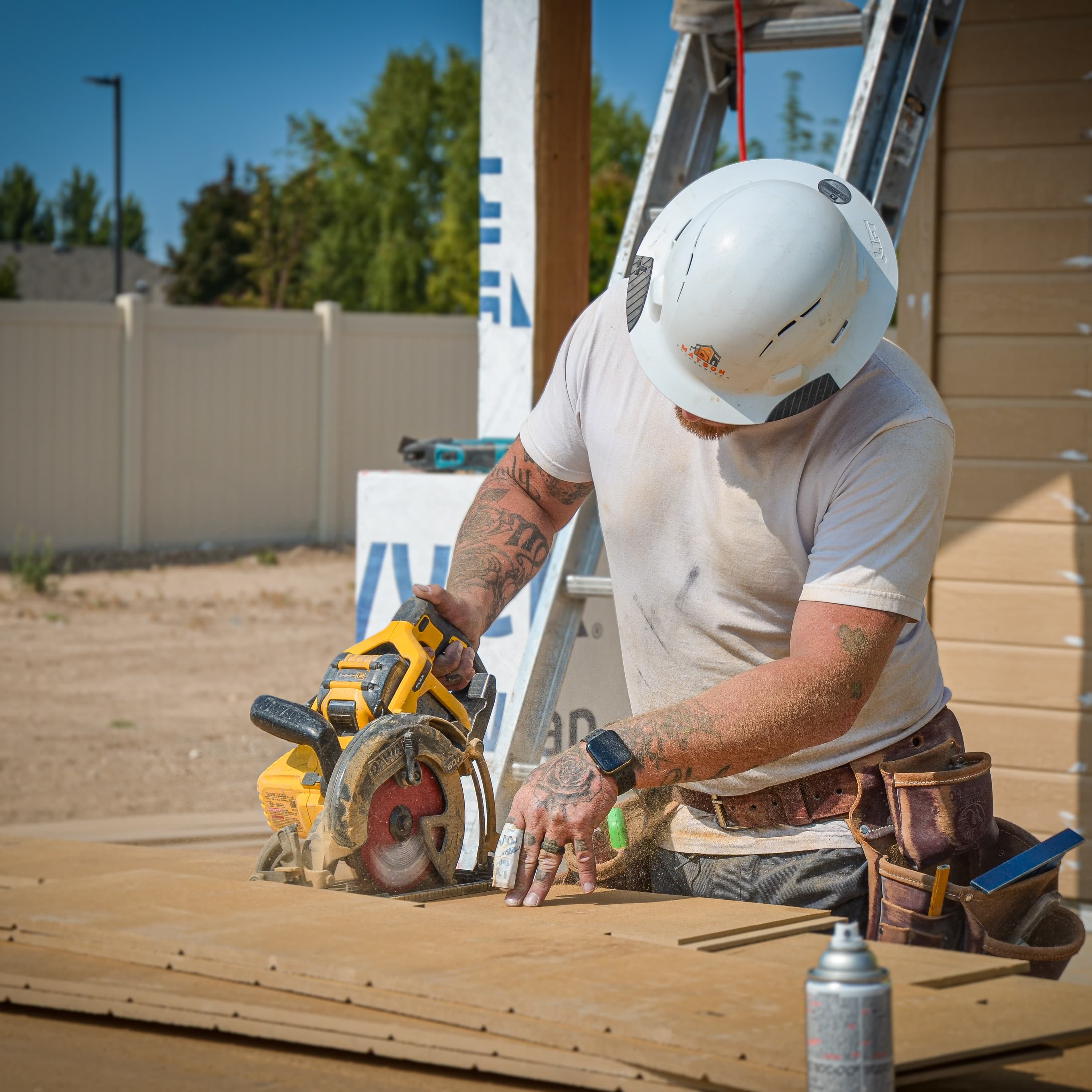 Crew member cutting siding with a saw